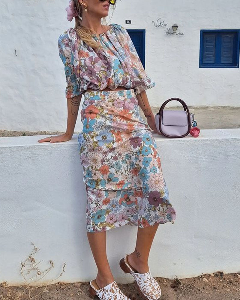 Zweiteiliges Set aus Oberteil mit Blumenmuster und Puffärmeln sowie Midi-Rock für den Urlaub